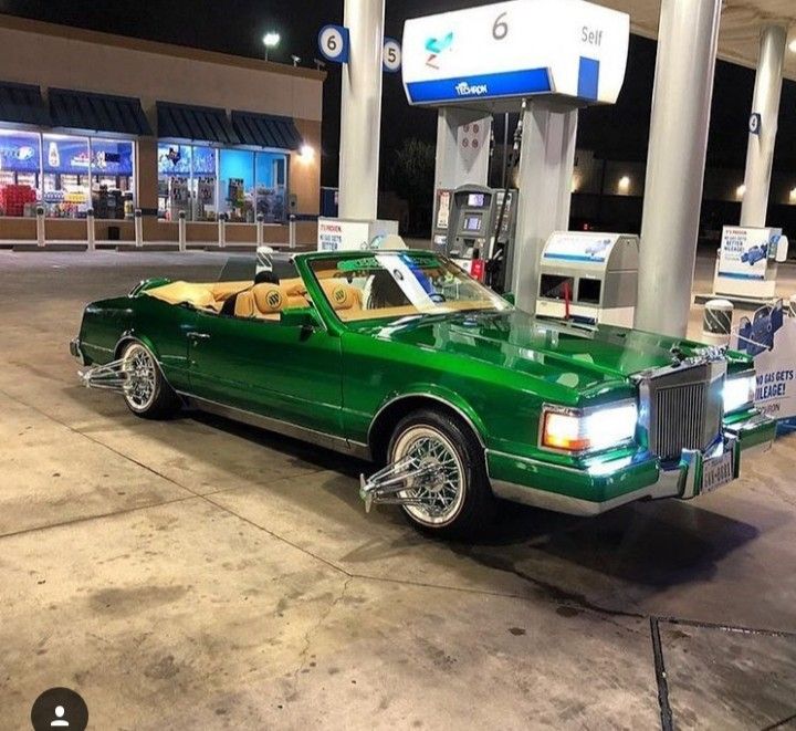 Candy green Lincoln Mark VII convertible slab on chrome wire swangas with tan leather interior, parked under gas station lights in Houston at night