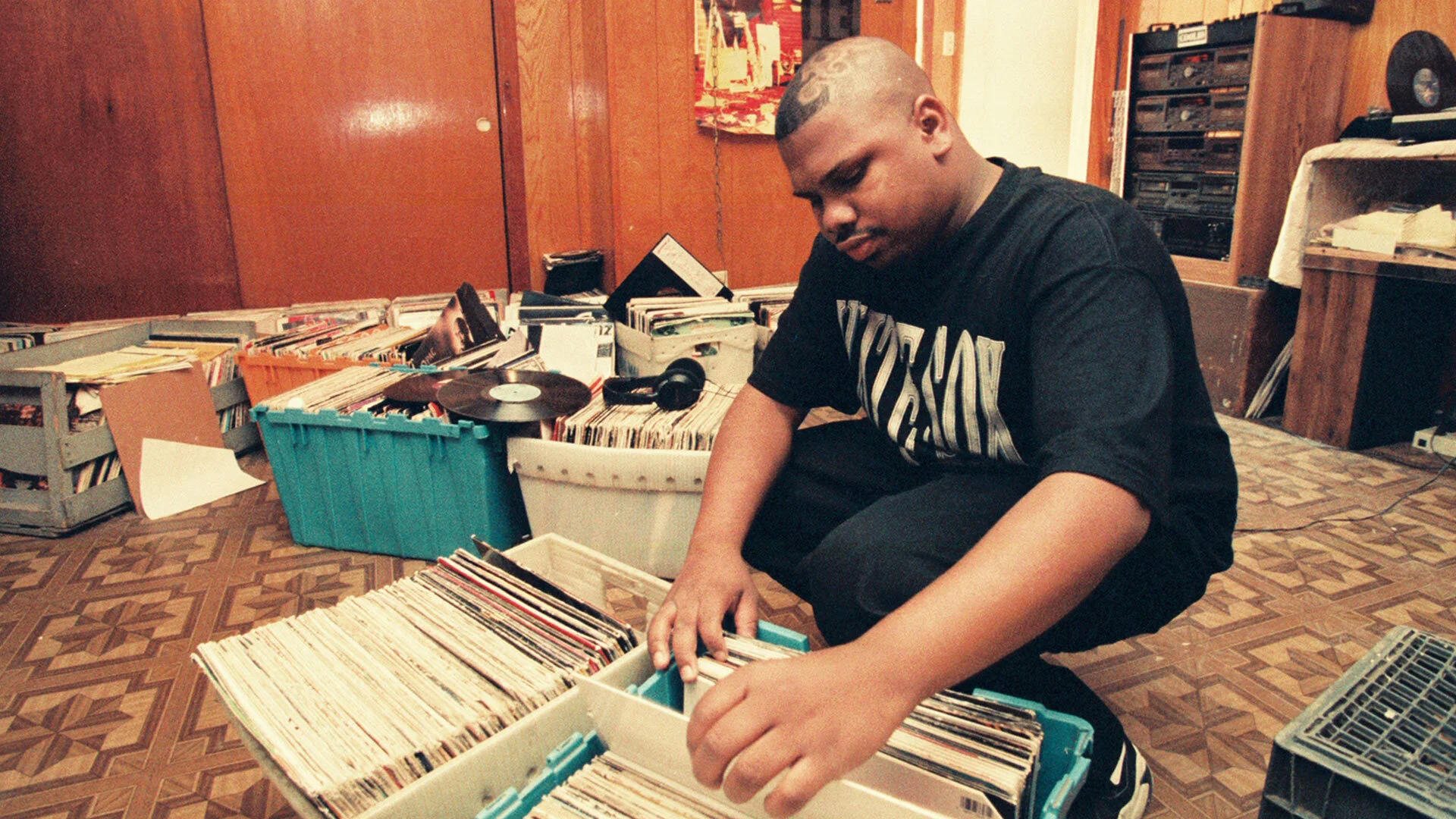DJ Screw digging through crates of records on the floor of his Houston home studio in the 1990s