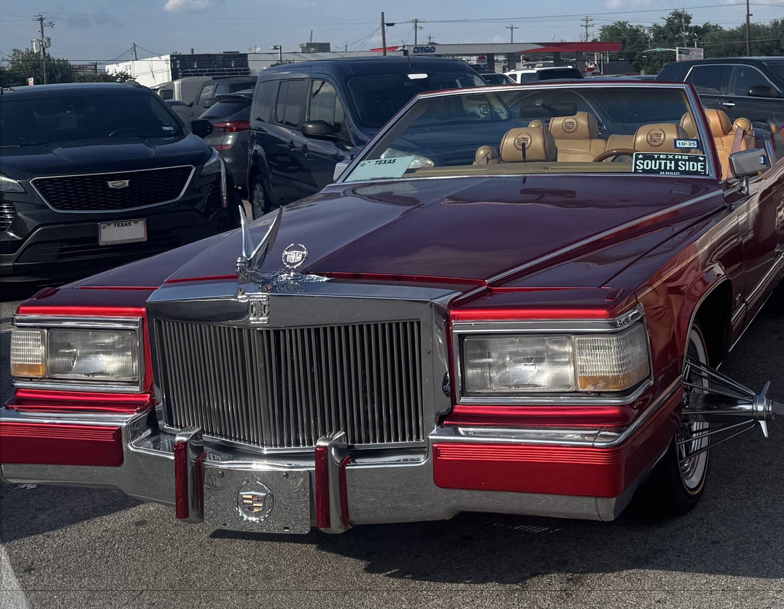 Candy red Cadillac convertible with chrome grille and tan guts on poked wire wheels in Texas