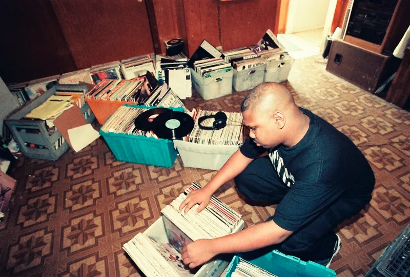 DJ Screw crouched over crates of vinyl in his Houston home studio, pulling records for a tape