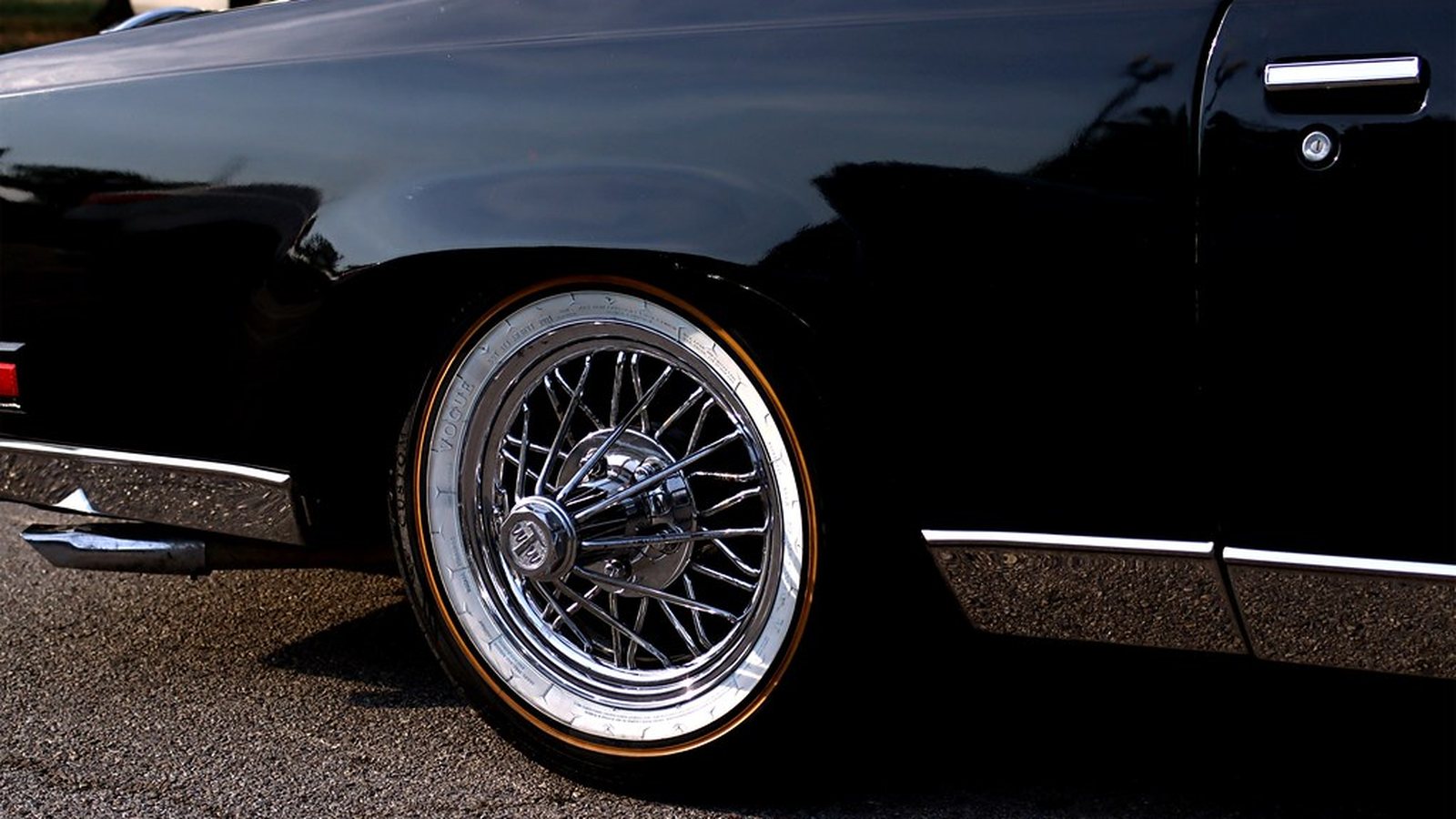 Close-up of a 30-spoke Texan wire swanga wheel poking out from a black slab